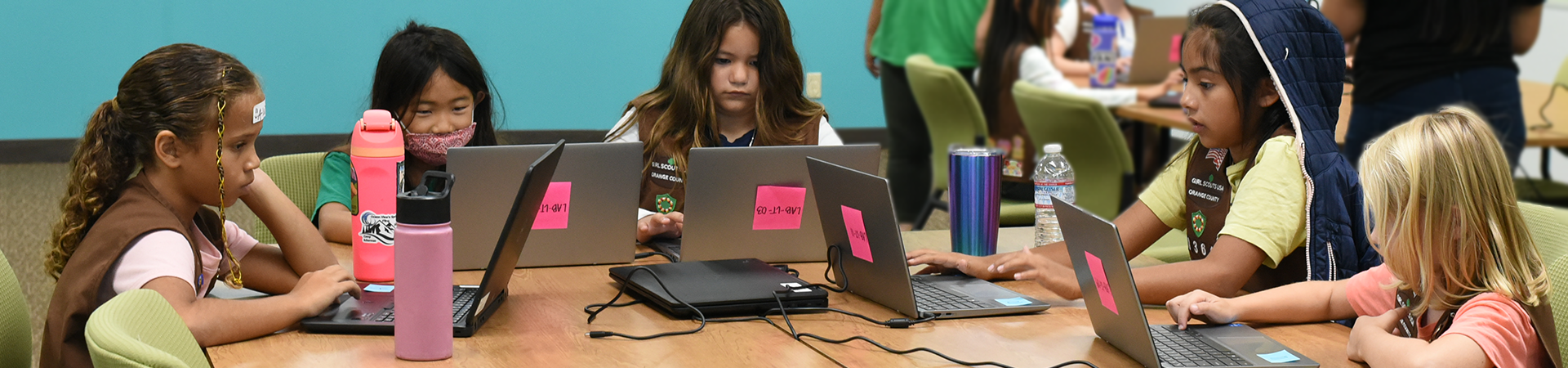  group of girl scouts looking at laptop computers 