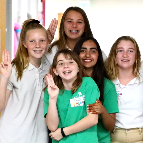 Girl Scouts doing the Girl Scout sign