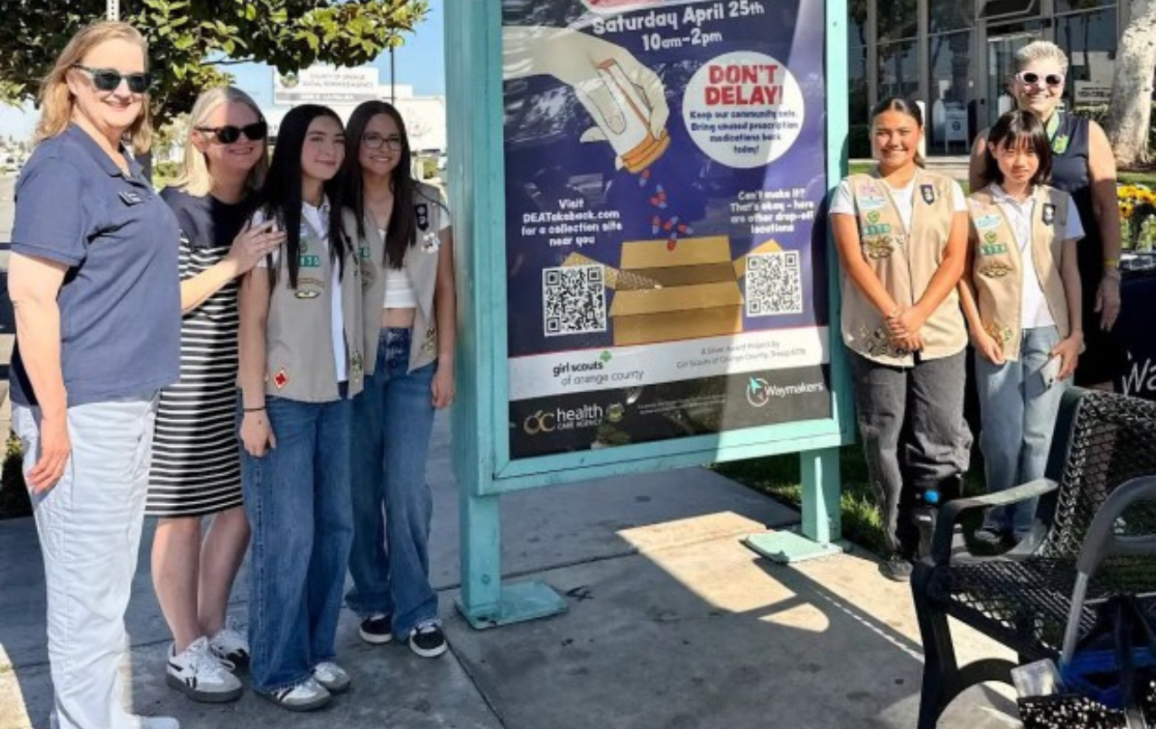 Waymakers CEO Ronnetta Johnson, with Girl Scouts of Troop 6170 and Girl Scouts of OC CEO Dr. Vikki Shepp stand next to bus shelter artwork in Anaheim that illustrates proper disposal of unused or expired medications.