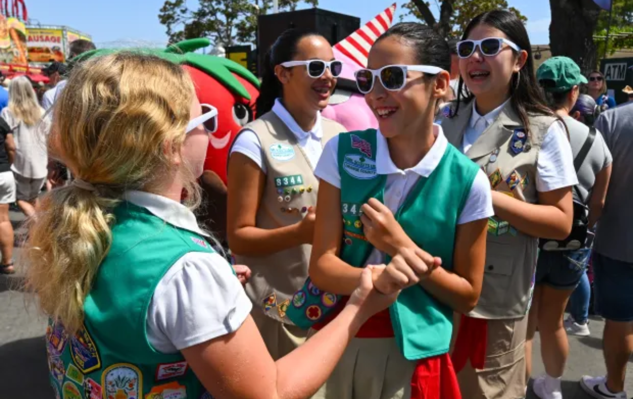 Ellie Toole and Ava Almaraz, of the Huntington Beach Girl Scout Flag Unit, dance to music during opening day at the OC Fair on Friday, July 17, 2026, in Costa Mesa.
